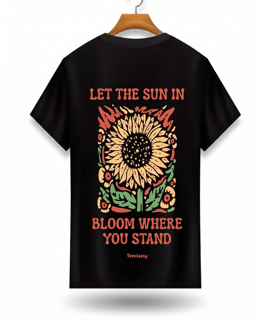 Black t-shirt with a sunflower design and text on a hanger against a white background