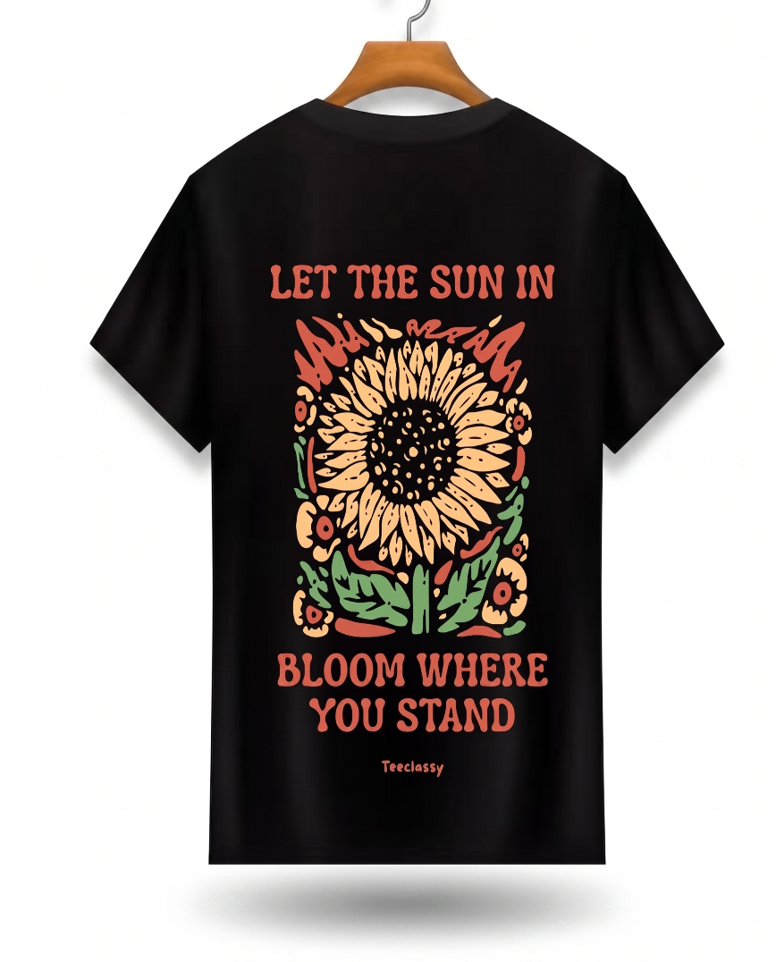 Black t-shirt with a sunflower design and text on a hanger against a white background